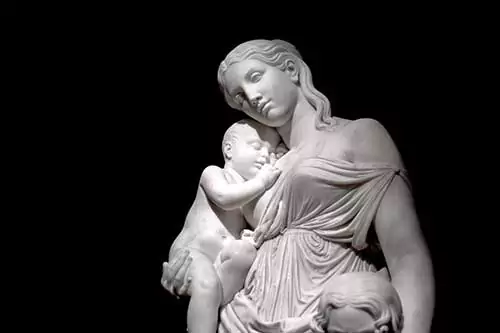 A sculpture of a mother holding baby